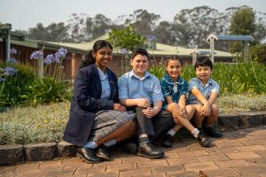 All Saints Catholic College Outreach - students sitting in front of school garden