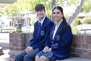 2 students sitting on a bench in the playground
